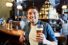 63601743-people-drinks-alcohol-and-leisure-concept-happy-young-man-drinking-draft-beer-at-bar-or.jpg