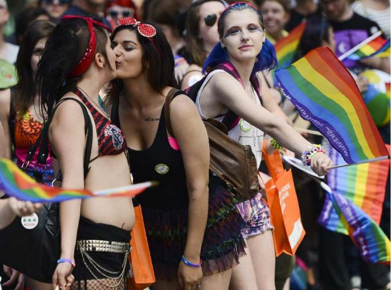 couple shares a kiss during the capital pride parade on bank e1439740494692